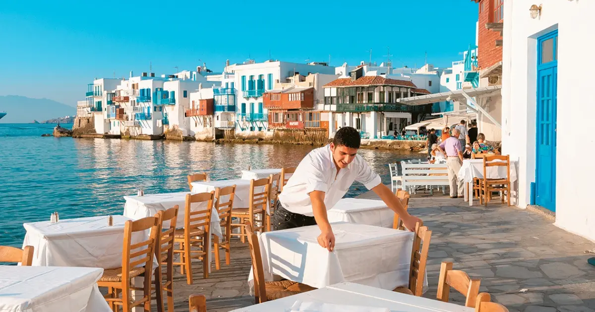 Οι ειδικότητες της πρώτης γραμμής, όπως οι ρεσεψιονίστ, οι μάγειρες και το προσωπικό καθαριότητας, καταγράφουν τη μεγαλύτερη αύξηση αποδοχών στον ελληνικό τουρισμό το 2026, καθώς οι εργοδότες αναγκάζονται να προσφέρουν μισθούς σημαντικά υψηλότερους από τα όρια των συλλογικών συμβάσεων για να καλύψουν τα χιλιάδες κενά.