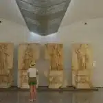 Το Υπουργείο Πολιτισμού προχωρά στην προκήρυξη 300 μόνιμων θέσεων για αρχαιοφύλακες (ΔΕ Ημερήσιων Φυλάκων και ΔΕ Νυχτοφυλάκων) σε μουσεία και αρχαιολογικούς χώρους ολόκληρης της χώρας μέσω του ΑΣΕΠ. Η έκδοση του νέου αυτού διαγωνισμού στοχεύει στην άμεση θωράκιση των υποδομών της πολιτιστικής μας κληρονομιάς, καλύπτοντας πάγια κενά εν μέσω μιας ακόμη δυναμικής τουριστικής περιόδου.
